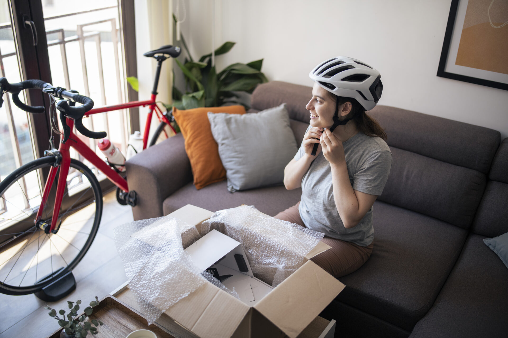 Young woman trying on new helmet from delivery.